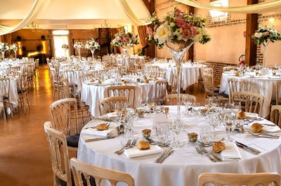 Buffet de petit-déjeuner avec viennoiseries, confitures, pains et boissons, près d'une baie vitrée donnant sur un jardin.
