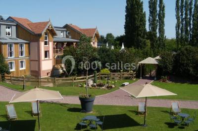 Buffet de petit-déjeuner avec viennoiseries, confitures, pains et boissons, près d'une baie vitrée donnant sur un jardin.