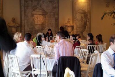 Terrain de tennis en plein air entouré de végétation et d'arbres, avec une clôture grillagée.
