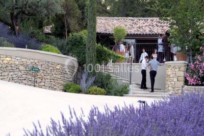 Terrain de tennis en plein air entouré de végétation et d'arbres, avec une clôture grillagée.