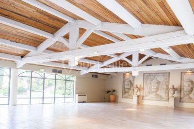 Terrain de tennis en plein air entouré de végétation et d'arbres, avec une clôture grillagée.