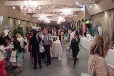 Terrain de tennis en plein air entouré de végétation et d'arbres, avec une clôture grillagée.