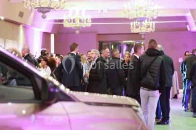 Terrain de tennis en plein air entouré de végétation et d'arbres, avec une clôture grillagée.