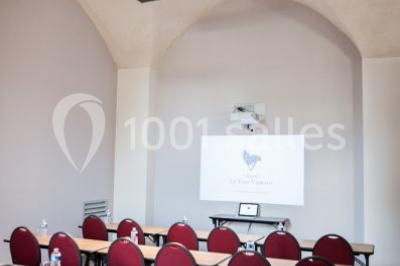 Terrain de tennis en plein air entouré de végétation et d'arbres, avec une clôture grillagée.