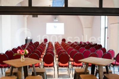 Terrain de tennis en plein air entouré de végétation et d'arbres, avec une clôture grillagée.