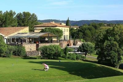 Table dressée en extérieur avec vue sur un paysage verdoyant, des collines et un terrain de golf au loin.