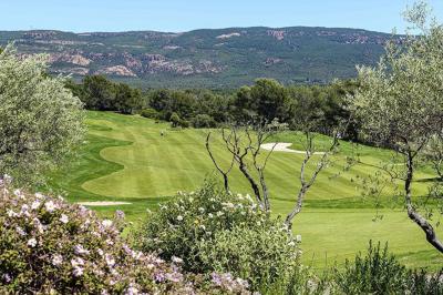 Table dressée en extérieur avec vue sur un paysage verdoyant, des collines et un terrain de golf au loin.
