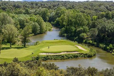 Table dressée en extérieur avec vue sur un paysage verdoyant, des collines et un terrain de golf au loin.