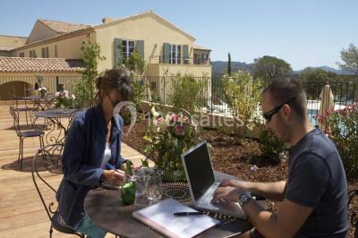 Table dressée en extérieur avec vue sur un paysage verdoyant, des collines et un terrain de golf au loin.