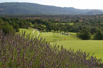 Table dressée en extérieur avec vue sur un paysage verdoyant, des collines et un terrain de golf au loin.
