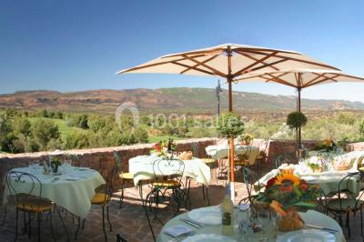 Table dressée en extérieur avec vue sur un paysage verdoyant, des collines et un terrain de golf au loin.