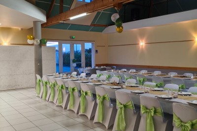 Salle de réception vide avec tables dressées pour un buffet, décor sobre et éclairage intérieur.