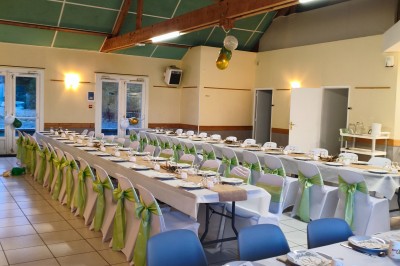 Salle de réception vide avec tables dressées pour un buffet, décor sobre et éclairage intérieur.