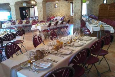 Chemin de gravier bordé de murets en pierre, menant à un paysage rural avec champs et arbres.