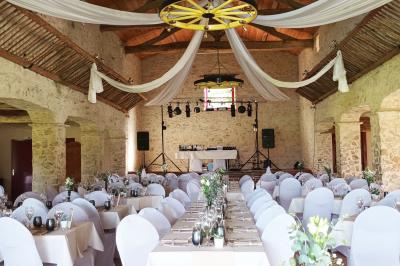 Chemin de gravier bordé de murets en pierre, menant à un paysage rural avec champs et arbres.