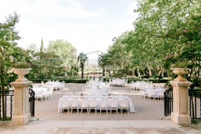 Un couple danse sous des guirlandes lumineuses devant un bâtiment éclairé en rouge, de nuit.
