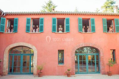 Un couple danse sous des guirlandes lumineuses devant un bâtiment éclairé en rouge, de nuit.
