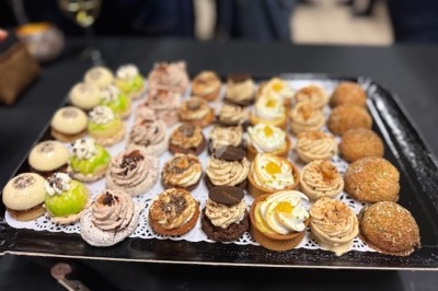Gâteau à plusieurs étages décoré de fraises, myrtilles et roses rouges, avec des pailles en décoration.