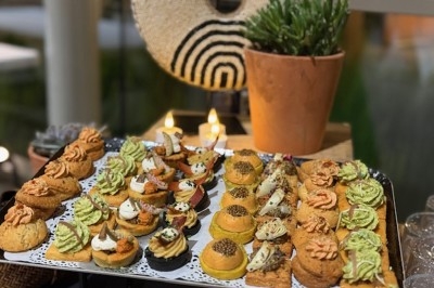 Gâteau à plusieurs étages décoré de fraises, myrtilles et roses rouges, avec des pailles en décoration.