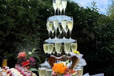 Gâteau à plusieurs étages décoré de fraises, myrtilles et roses rouges, avec des pailles en décoration.