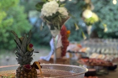 Gâteau à plusieurs étages décoré de fraises, myrtilles et roses rouges, avec des pailles en décoration.