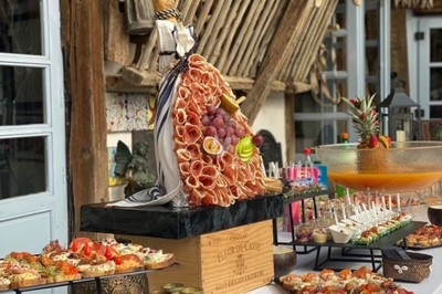 Gâteau à plusieurs étages décoré de fraises, myrtilles et roses rouges, avec des pailles en décoration.