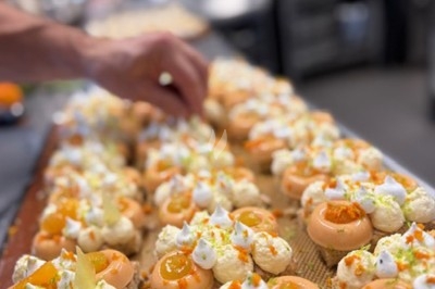 Gâteau à plusieurs étages décoré de fraises, myrtilles et roses rouges, avec des pailles en décoration.
