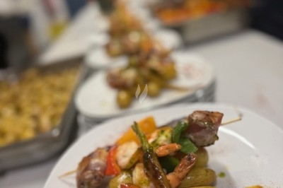 Gâteau à plusieurs étages décoré de fraises, myrtilles et roses rouges, avec des pailles en décoration.