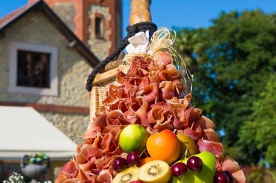 Gâteau à plusieurs étages décoré de fraises, myrtilles et roses rouges, avec des pailles en décoration.