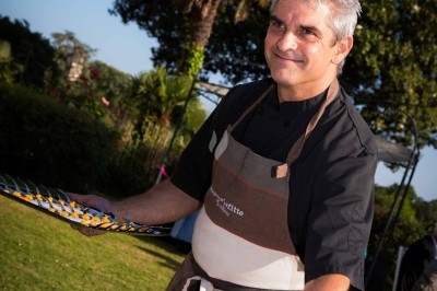 Gâteau à plusieurs étages décoré de fraises, myrtilles et roses rouges, avec des pailles en décoration.