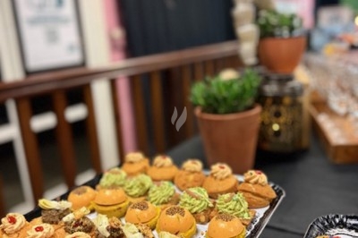 Gâteau à plusieurs étages décoré de fraises, myrtilles et roses rouges, avec des pailles en décoration.