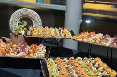 Gâteau à plusieurs étages décoré de fraises, myrtilles et roses rouges, avec des pailles en décoration.