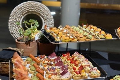 Gâteau à plusieurs étages décoré de fraises, myrtilles et roses rouges, avec des pailles en décoration.