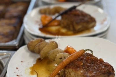 Gâteau à plusieurs étages décoré de fraises, myrtilles et roses rouges, avec des pailles en décoration.