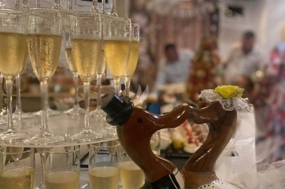 Gâteau à plusieurs étages décoré de fraises, myrtilles et roses rouges, avec des pailles en décoration.