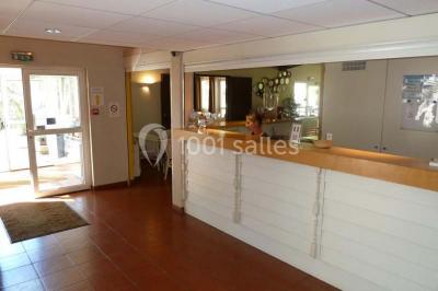 Comptoir de bar moderne en bois avec décorations murales de photos en noir et blanc dans un intérieur lumineux.