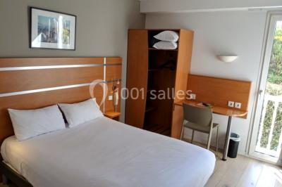 Comptoir de bar moderne en bois avec décorations murales de photos en noir et blanc dans un intérieur lumineux.