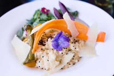 Table décorée pour un mariage avec livre d'or, lettres dorées, lampion rose et panneau en carton dans un cadre verdoyant.