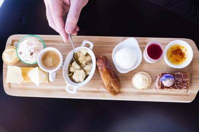 Table décorée pour un mariage avec livre d'or, lettres dorées, lampion rose et panneau en carton dans un cadre verdoyant.