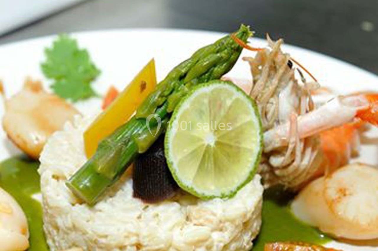 Assiette de risotto garni d'asperges, rondelle de citron vert, crevettes et noix de Saint-Jacques, avec sauce verte.