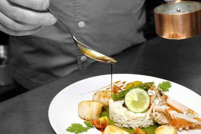 Table décorée pour un mariage avec livre d'or, lettres dorées, lampion rose et panneau en carton dans un cadre verdoyant.