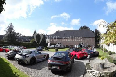 Vue d'un marché couvert avec des stands de produits locaux, des visiteurs et une architecture en pierre et bois.
