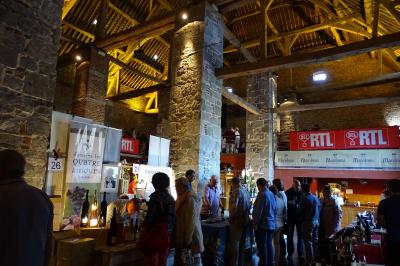 Vue d'un marché couvert avec des stands de produits locaux, des visiteurs et une architecture en pierre et bois.
