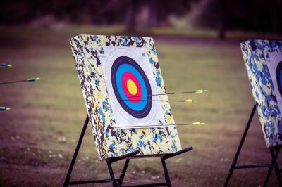 Vue d'un marché couvert avec des stands de produits locaux, des visiteurs et une architecture en pierre et bois.