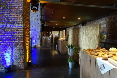 Vue d'un marché couvert avec des stands de produits locaux, des visiteurs et une architecture en pierre et bois.