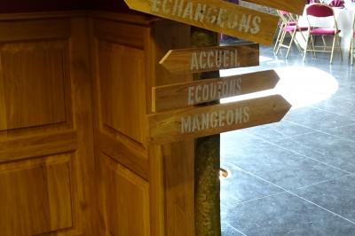 Vue d'un marché couvert avec des stands de produits locaux, des visiteurs et une architecture en pierre et bois.