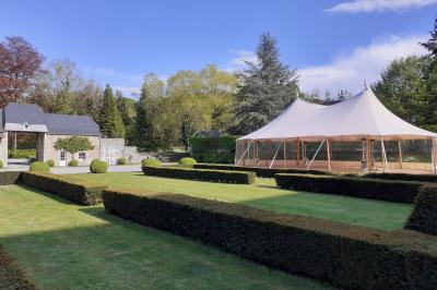 Vue d'un marché couvert avec des stands de produits locaux, des visiteurs et une architecture en pierre et bois.