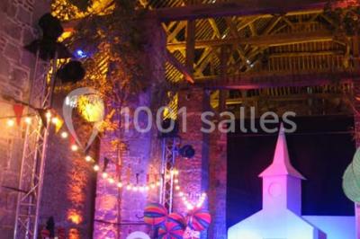 Vue d'un marché couvert avec des stands de produits locaux, des visiteurs et une architecture en pierre et bois.