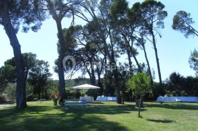Salle de réception avec une longue table dressée, nappes blanches, vaisselle élégante et décorations florales.
