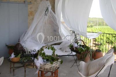 Salle de réception avec une longue table dressée, nappes blanches, vaisselle élégante et décorations florales.